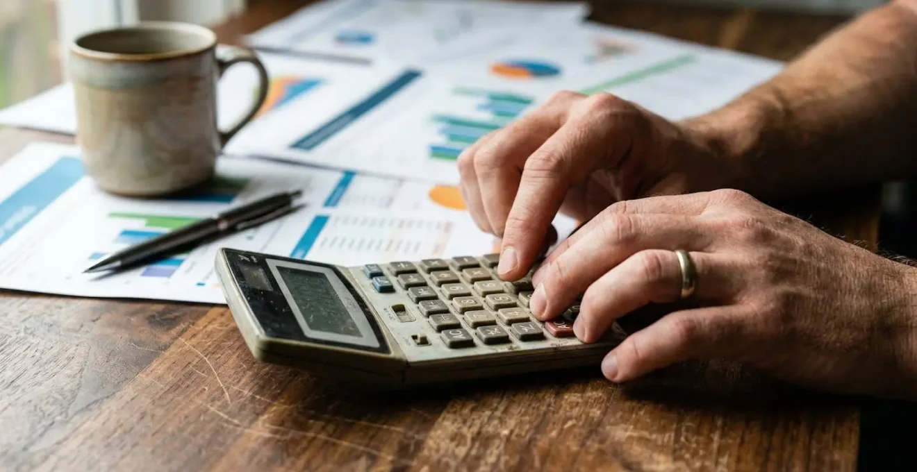 Bureau avec calculatrice et documents financiers pour le calcul du reste à charge d'une pompe à chaleur
