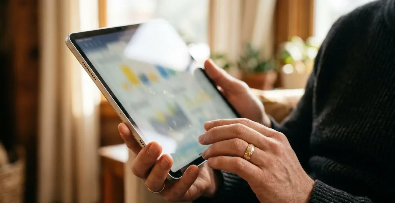 Main analysant des graphiques de consommation énergétique sur tablette avec courbes colorées